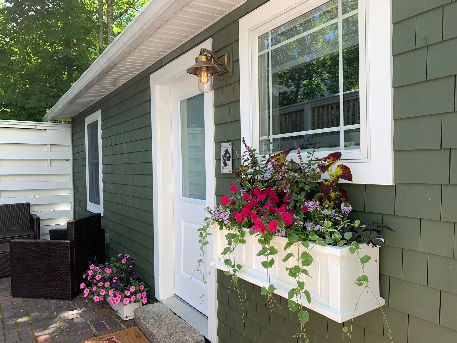 Ash Cottage entrance with green siding and flower boxes